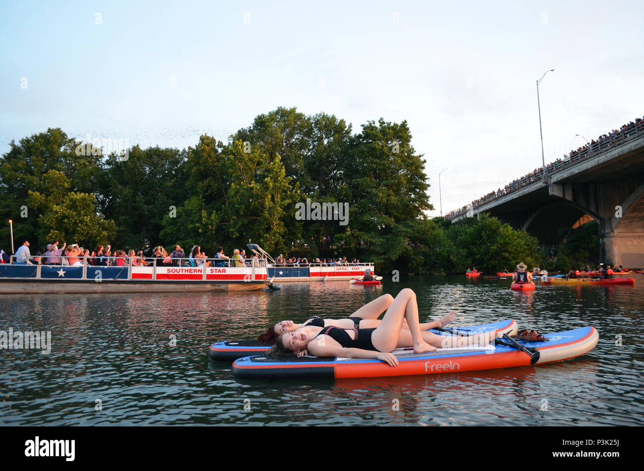 Deux filles paddle dans la soirée pour regarder la le Congrès ave les chauves-souris sortent sur le lac Coccinelle à Austin, Texas. Banque D'Images