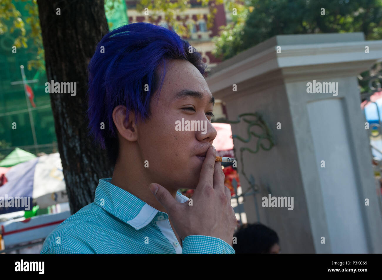 Yangon, Myanmar, adolescent fume une cigarette Banque D'Images