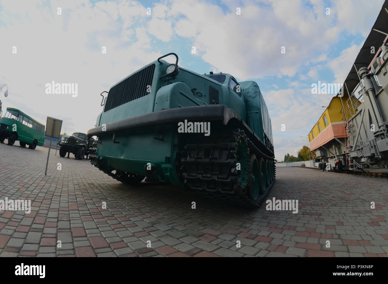 Photo d'une voiture blindée vert russe sur une voie caterpillar parmi les trains de chemin de fer. Une forte distorsion de l'objectif fisheye Banque D'Images
