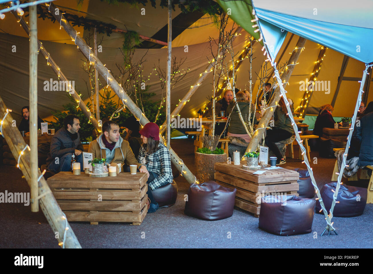 Londres, UK - Novembre 2017. Les gens de boire dans un bar et grill tente dans Broadgate, où une forêt dite d'inspiration nordique de la forêt d'hiver est installé. Banque D'Images