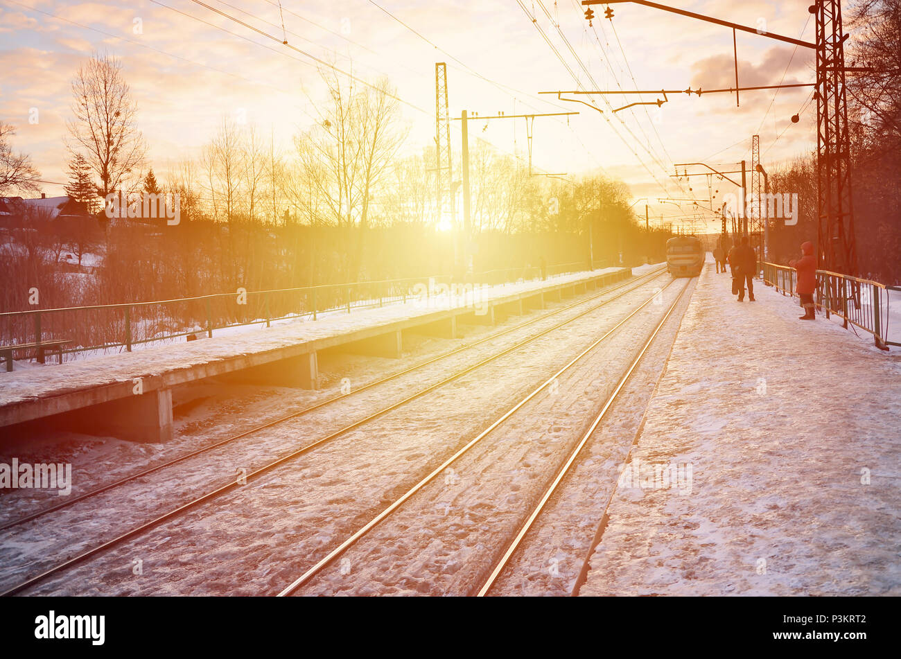 Photo de lumineux et beau coucher de soleil sur un ciel nuageux en saison froide d'hiver. Voie de chemin de fer avec des plates-formes pour les trains en attente de transmission de puissance et de lin Banque D'Images