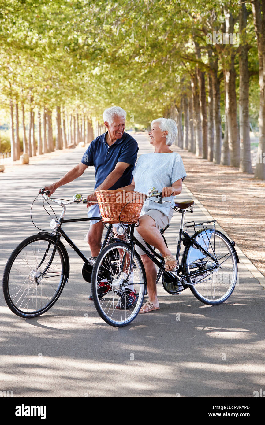 Happy Senior Couple Cycling On Country Road Banque D'Images