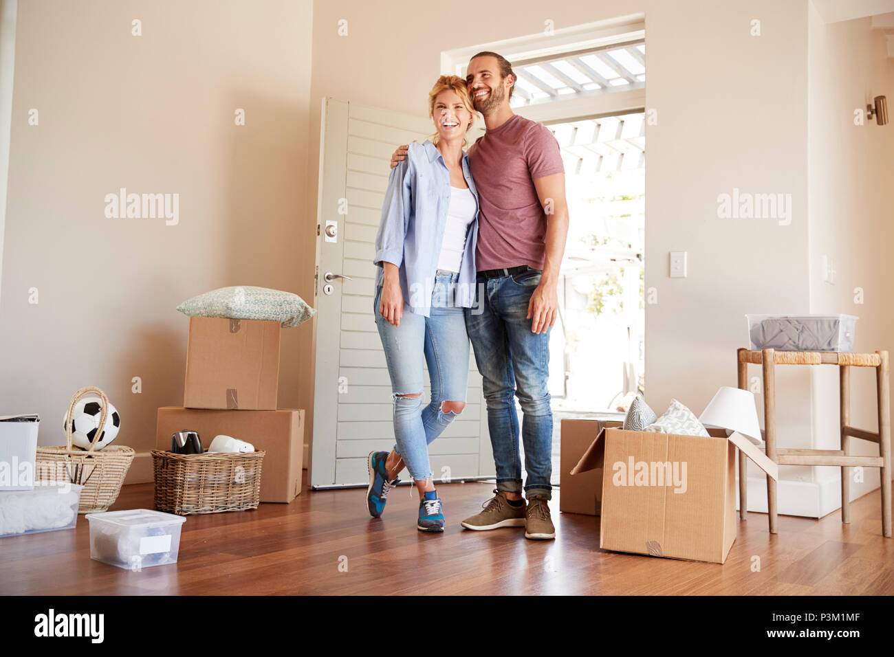 Heureux Couple entouré par des boîtes à New Home le jour du déménagement Banque D'Images