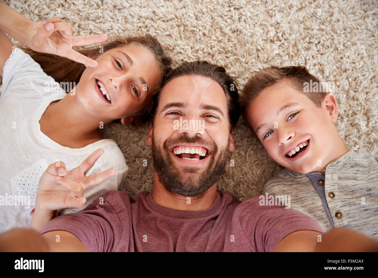 Point de vue tourné de père et d'enfants posant pour Selfies Banque D'Images