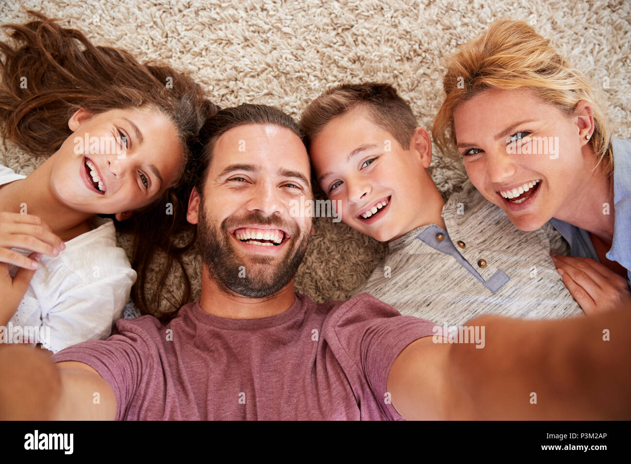 Coup de point de vue des parents et des enfants posant pour Selfies Banque D'Images