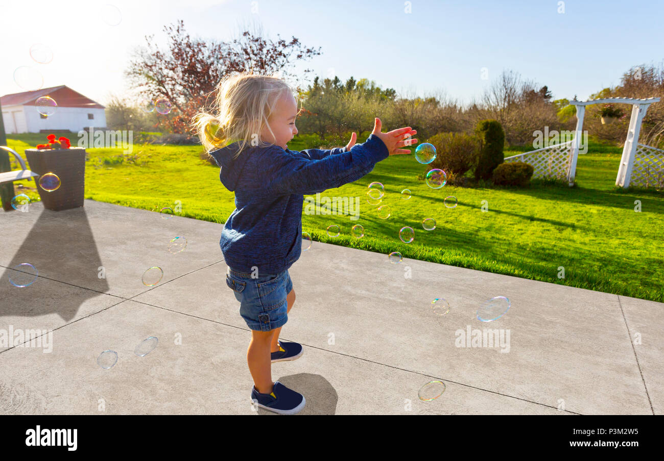 Portrait enfant jouant avec des bulles de savon en plein air Banque D'Images