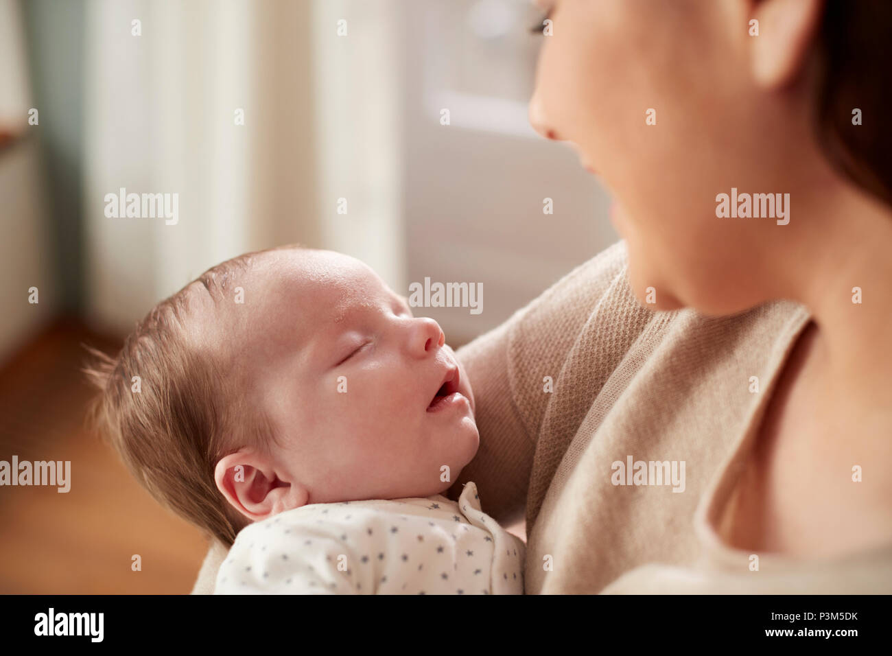 Close Up of Sleeping Newborn Baby étant détenu par Mère Banque D'Images