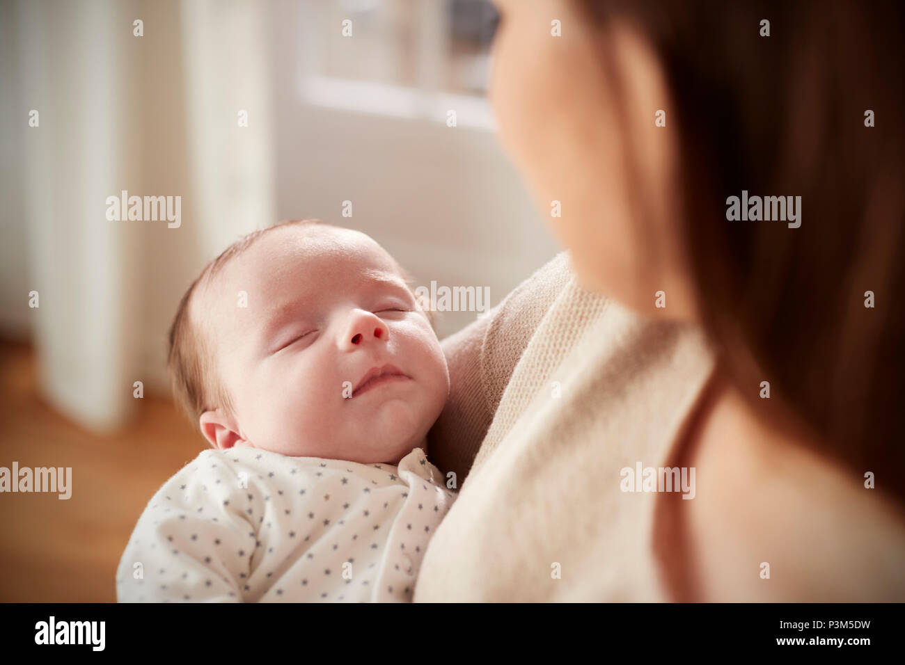 Close Up of Sleeping Newborn Baby étant détenu par Mère Banque D'Images