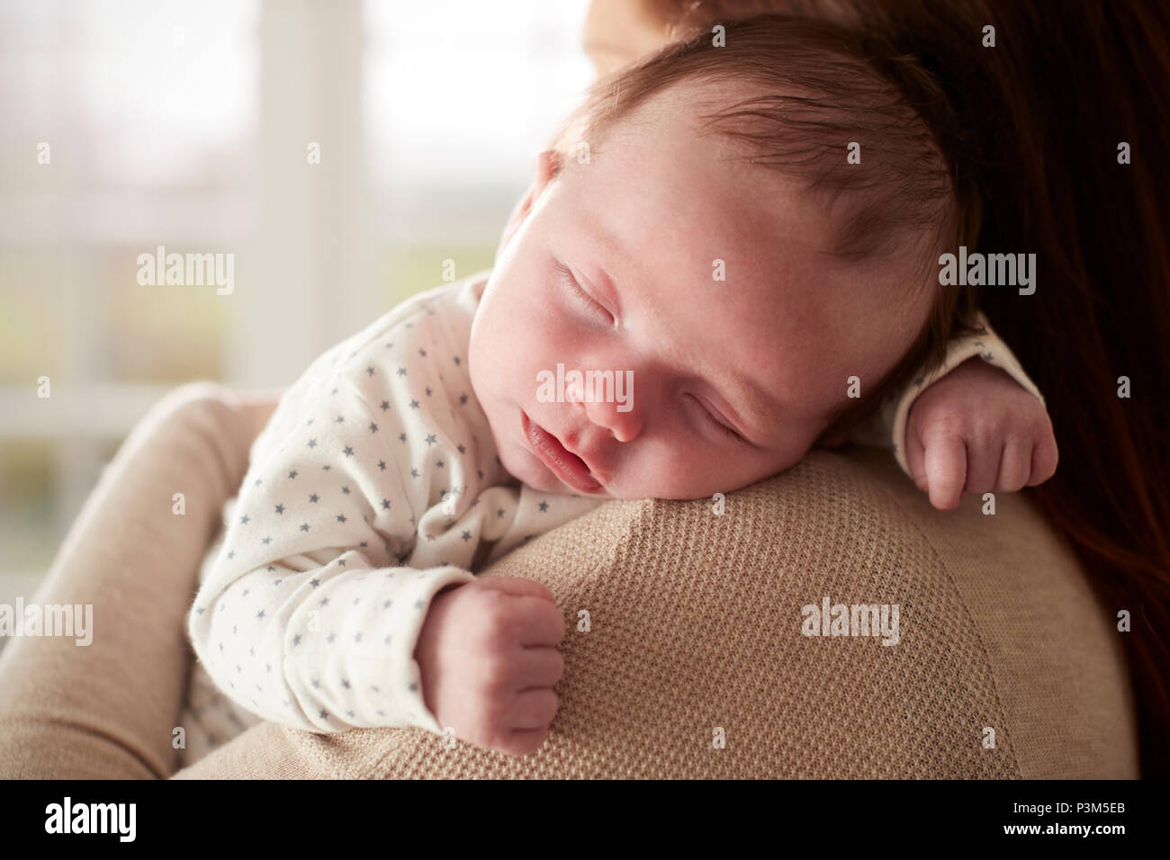Close Up of newborn Baby Sleeping dormir sur l'épaule de mères Banque D'Images