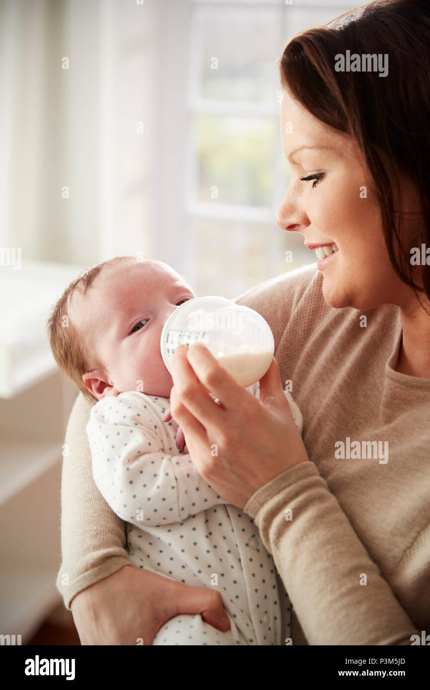 L'alimentation de la mère bébé nouveau-né à partir de la bouteille à la maison Banque D'Images