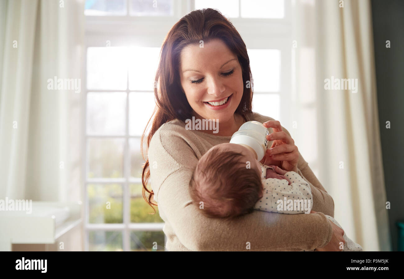 L'alimentation de la mère bébé nouveau-né à partir de la bouteille à la maison Banque D'Images