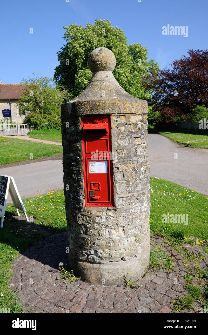 Ce pilier unique fort à Nether Upper Winchendon, Buckinghamshire, datant de 1850, se dresse sur un cercle de briques, sur un petit triangle vert . Banque D'Images