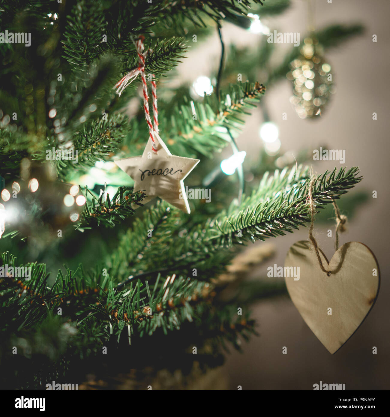 Vue rapprochée d'un arbre de Noël décoré avec des étoiles et des décors en forme de coeur. Maison de concept. Format carré. Banque D'Images