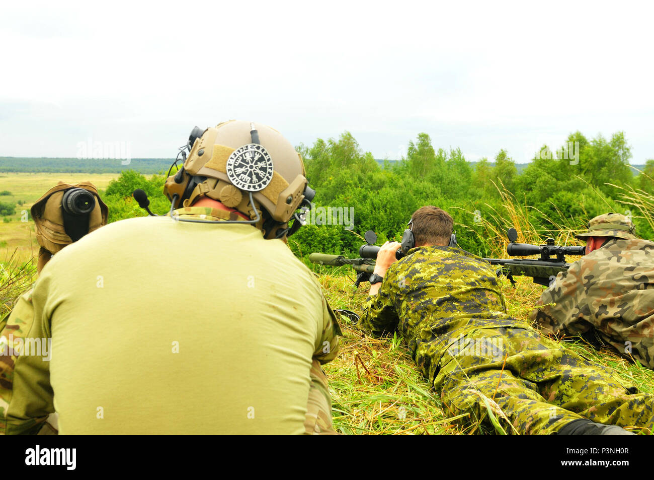 L'viv, Ukraine--A LES FORCES SPÉCIALES L'opérateur observe coups de feu tiré par un soldat Canadien de calibre .308 un fusil de sniper et un soldat polonais de fusil sniper calibre .50 ici le 18 juillet. La gamme a donné les partenaires multinationaux multinational interarmées à Group-Ukraine l'occasion de découvrir divers fusils de précision à partir des États-Unis, le Canada et l'Ukraine. JMTG-U est un effort multinational pour former des unités de combat défensif ukrainien sur les compétences nécessaires pour accroître la capacité de l'Ukraine pour l'auto-défense. (U.S. Photo de l'armée par le Capitaine Scott Kuhn) Banque D'Images