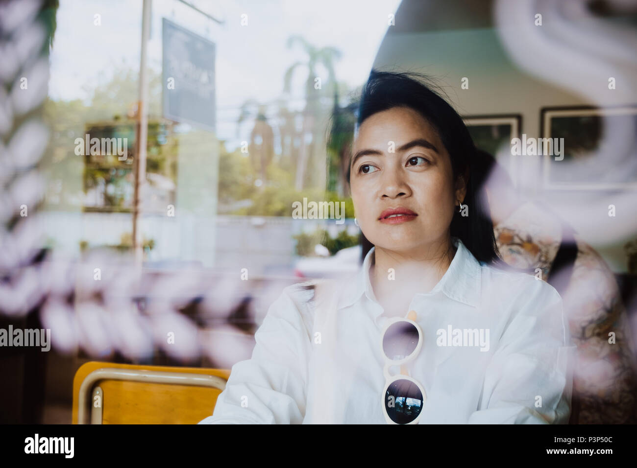 Asian woman sitting in coffee shop près de la réflexion de la fenêtre avec émotion,vie loisirs détente Banque D'Images