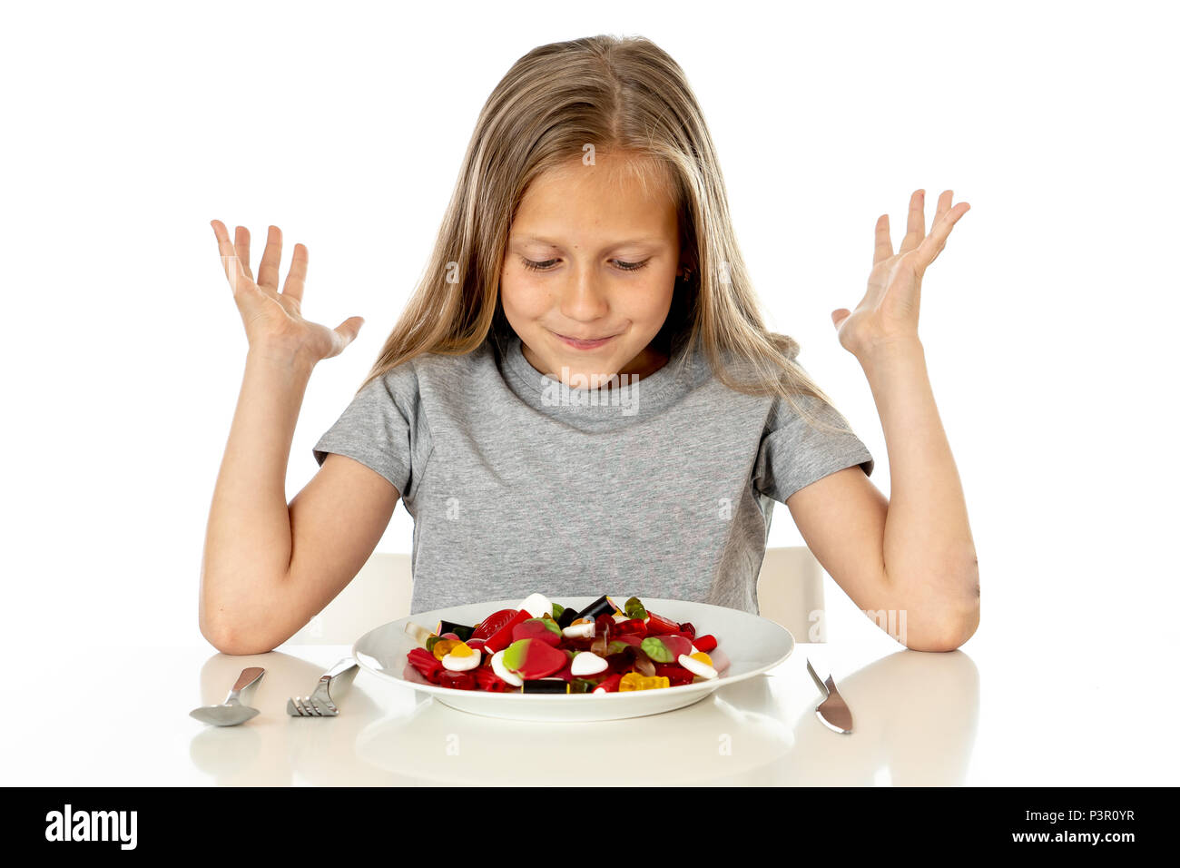 Funny happy girl avec la plaque de bonbons sucette lollies happy little girl eating big sugar candy lollies kid manger des sucreries. surpris enfant avec des bonbons. iso Banque D'Images