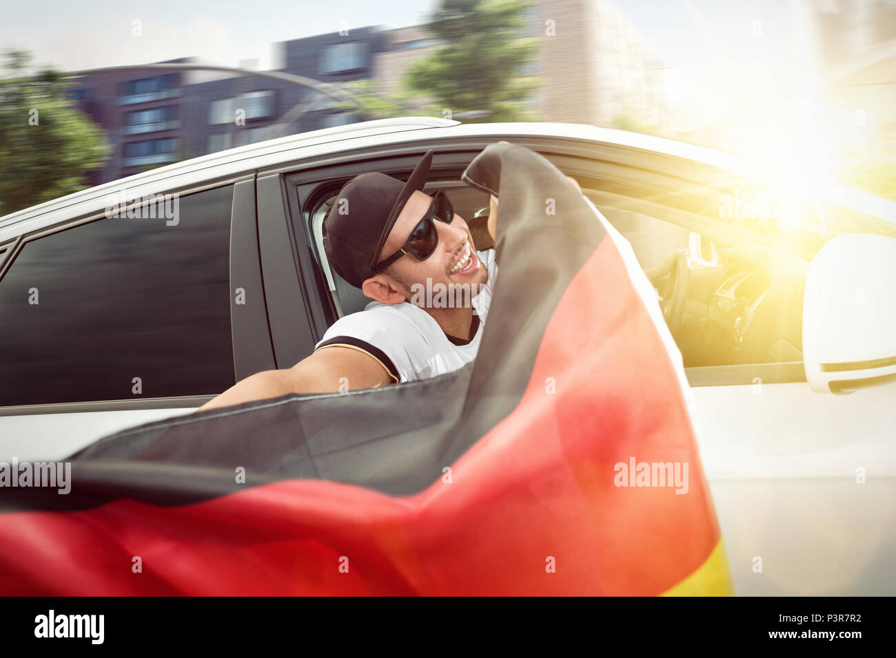 Fan de football allemand brandissant un drapeau hors de la fenêtre d'une voiture Banque D'Images