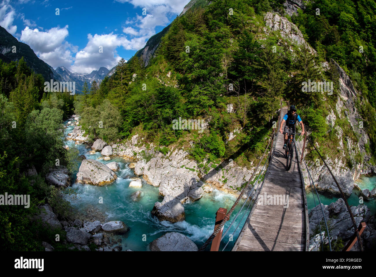 Une des promenades en vélo de montagne à travers un pont de bois sur la rivière Soca en Slovénie, l'Europe. Banque D'Images