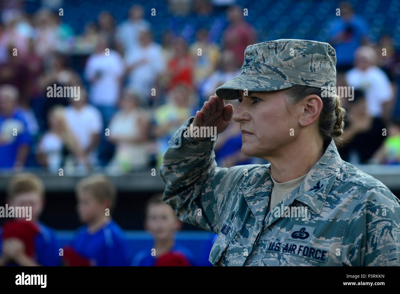 Au stade de baseball de Norfolk, en Virginie, un groupe de l’US Air Force joue « The Star‑Spangled Banner » lors de la soirée d’appréciation de l’Air Force, honorant la joint base Langley‑Eustis et célébrant les 100 ans de puissance aérienne sur Hampton Roads. Les participants comprennent des aviateurs militaires, des gardes d'honneur et des membres de la communauté. Un F-22 Raptor, un avion de chasse bimoteur de cinquième génération équipé de moteurs Pratt & Whitney F119‑PW‑100, est mis en évidence dans les affichages associés. Banque D'Images