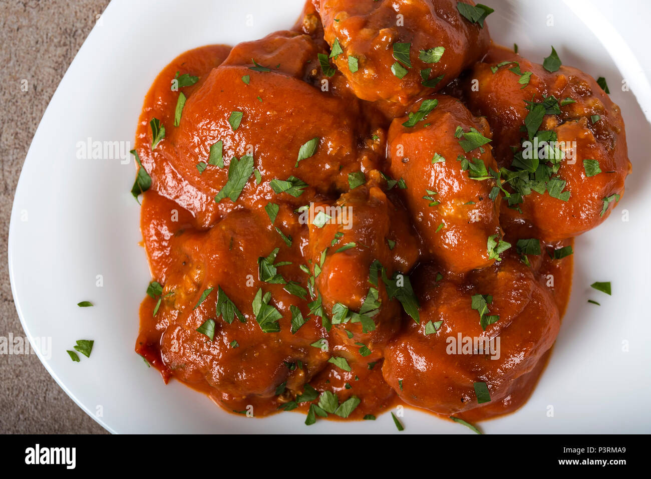 Boulettes de viande avec sauce tomate et persil frais haché sur platine - Vue de dessus Banque D'Images