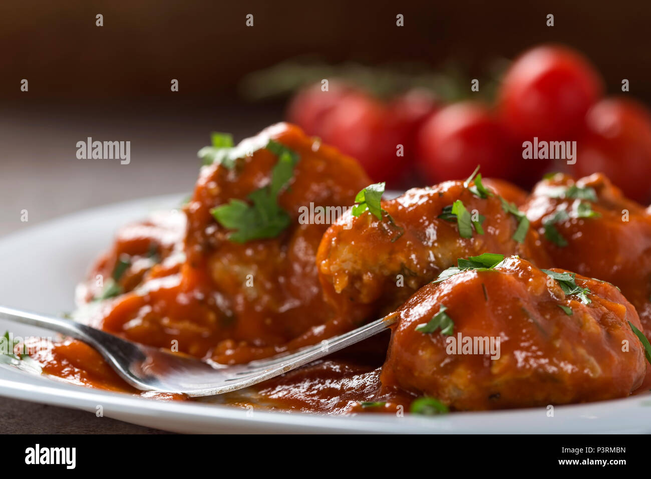 Boulettes de viande avec sauce tomate et persil frais haché sur la plaque avec une fourchette - vue rapprochée Banque D'Images