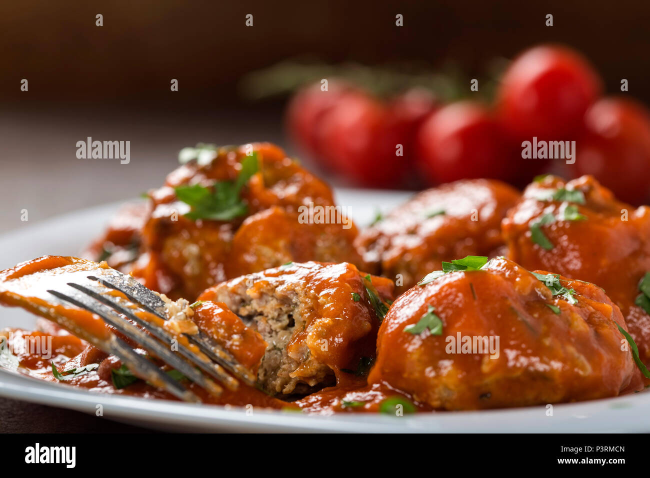 Boulettes de viande avec sauce tomate et persil frais haché sur la plaque avec une fourchette - vue rapprochée Banque D'Images