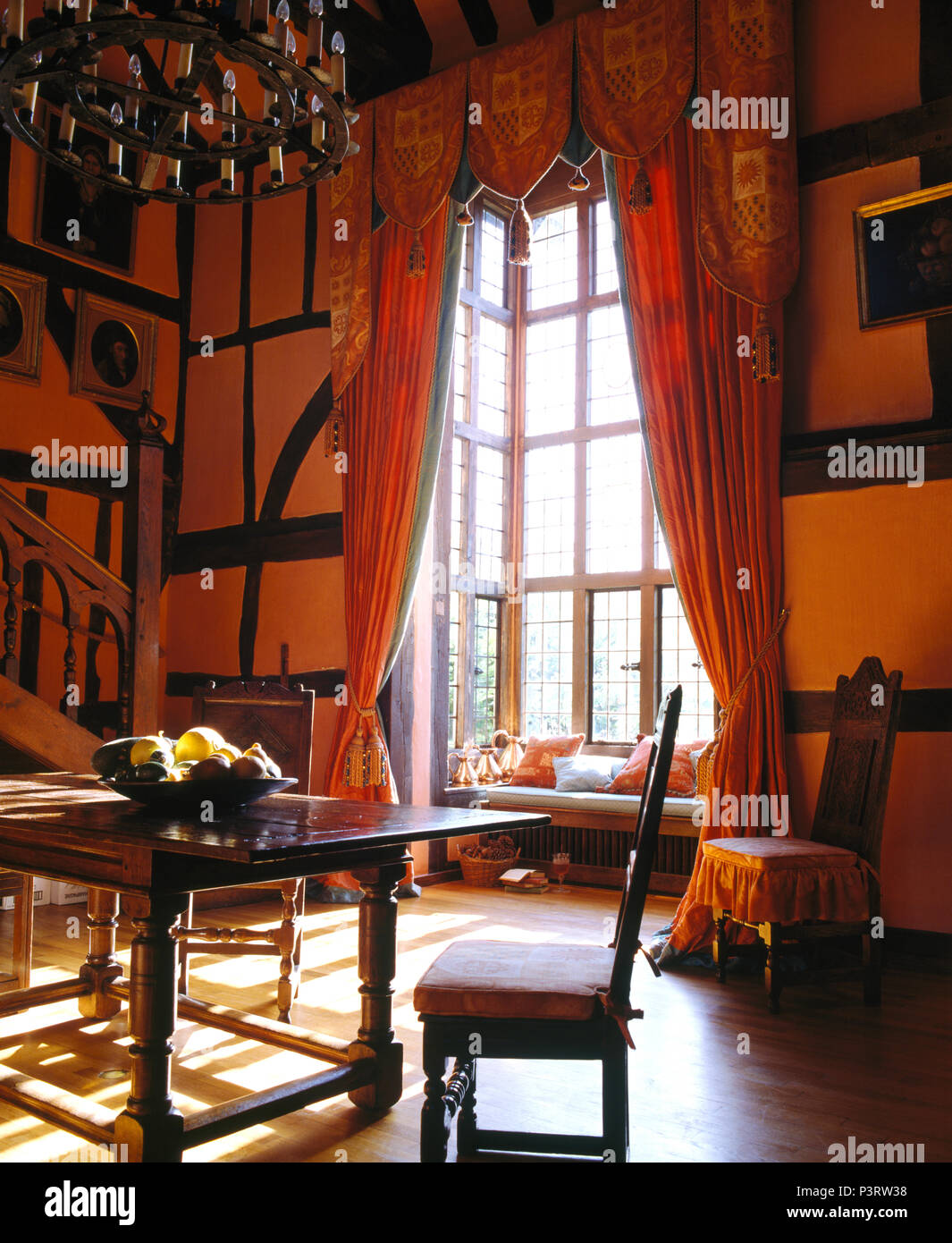 Rideaux rouge-orange à hautes fenêtres dans grande maison de campagne salle  à manger avec meubles anciens Photo Stock - Alamy