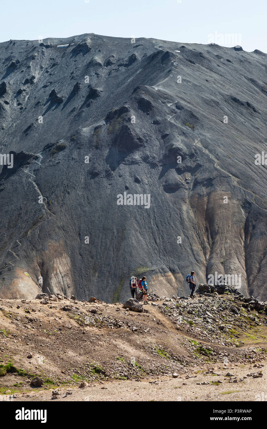 Randonneurs sur le sentier Laugavegur avec la montagne volcanique de Blahnukur en toile de fond, Landmannalaugar, Islande. Banque D'Images