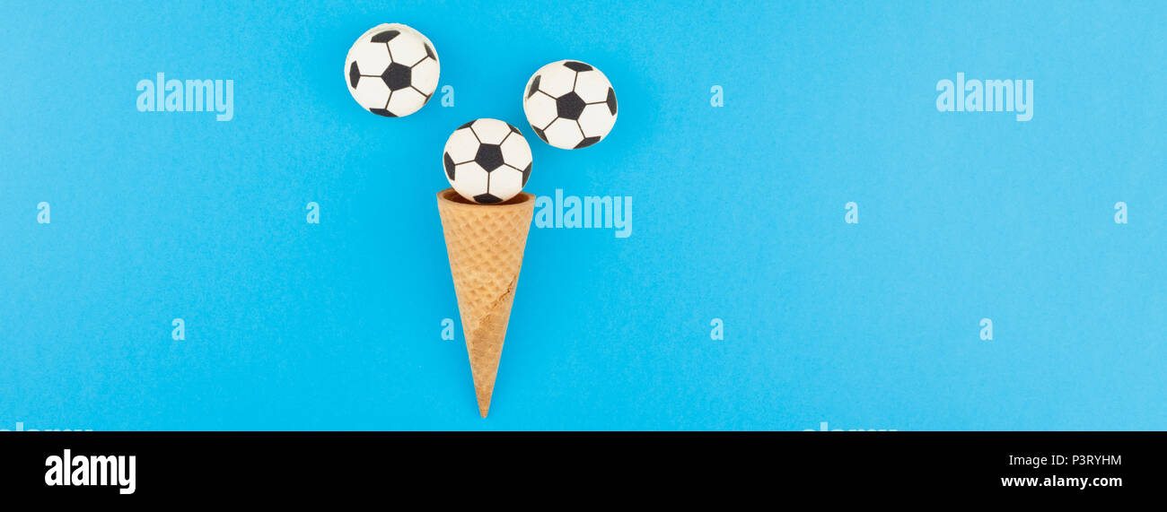 Bannière longue et large vue de dessus de la crème glacée cônes alvéolés avec des ballons de foot macarons sur fond bleu clair bold avec copie espace dans un style minimaliste, concep Banque D'Images