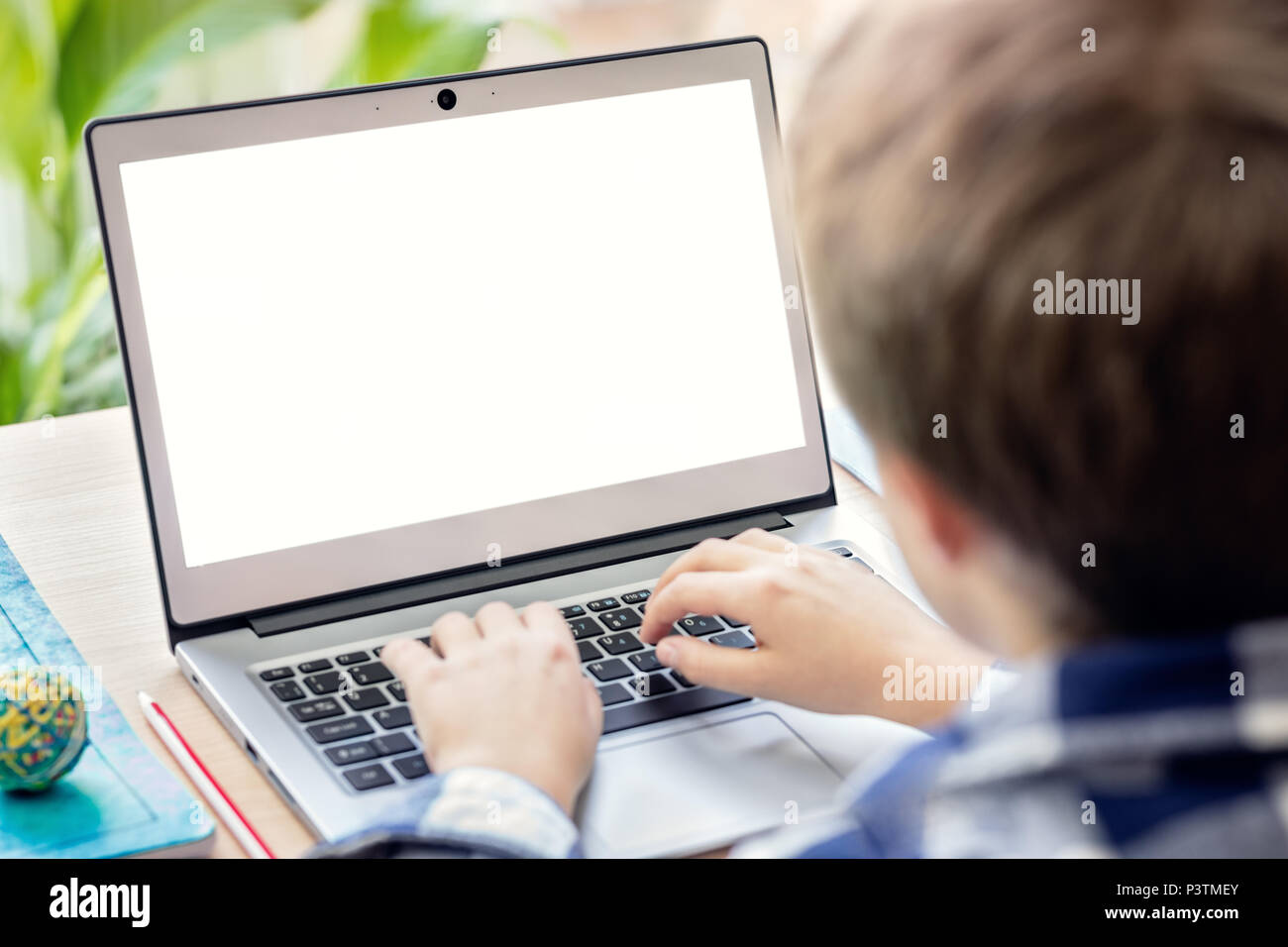Garçon sur l'internet avec un ordinateur portable à faire des devoirs avec écran vide Banque D'Images