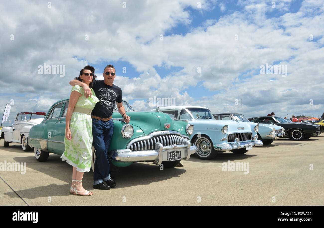 Un couple pose devant leur voiture classique au cours de la toute première manifestation Wings and Wheels at Royal Air Force Lakenheath, Angleterre, le 2 juillet. Wings and Wheels se compose d'un salon de voitures, carnaval des manèges, des avions statiques, d'artifice et d'un saut en parachute la RAF Falcons display team. (U.S. Air Force photo/Senior Airman Nigel Sandridge) Banque D'Images