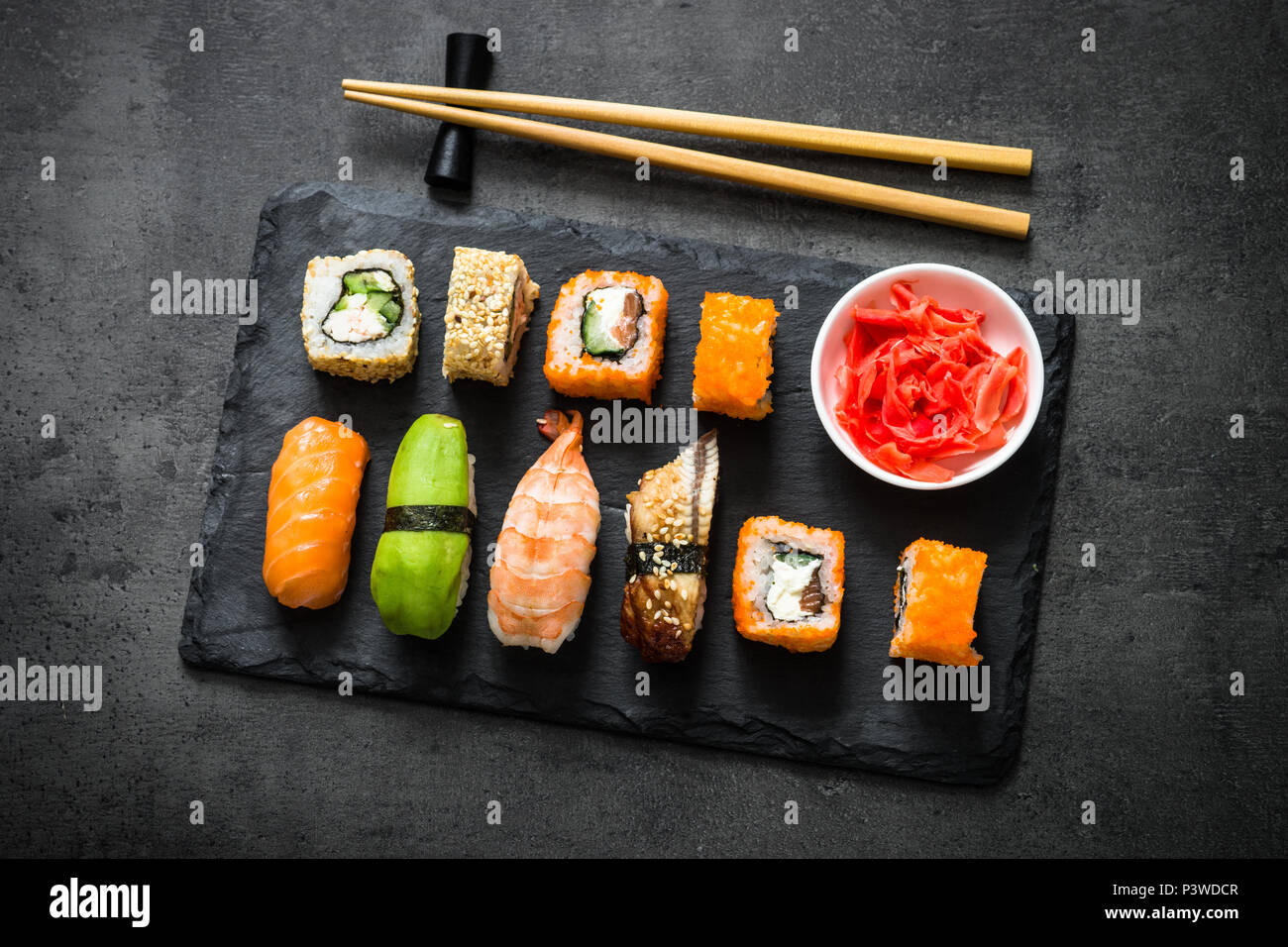 Sushi et sushi roll set sur table en pierre noire vue d'en haut. Cuisine asiatique traditionnelle. Banque D'Images