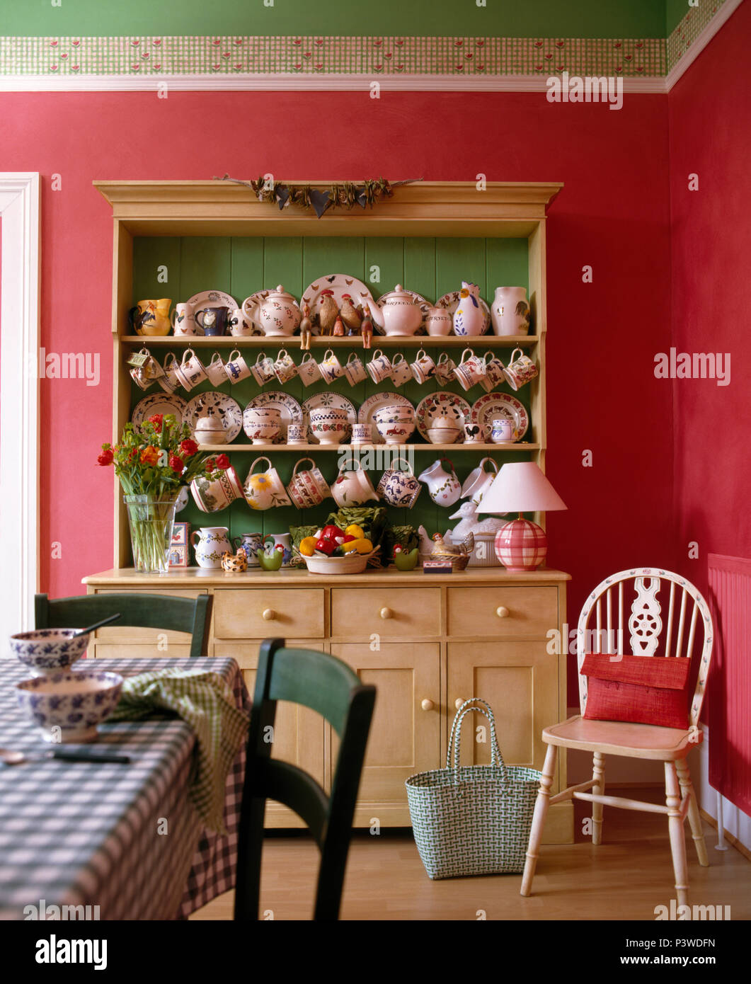 Collection de bols de poterie et les plaques sur grand vaisselier pin rose profond en salle à manger avec chaise Windsor Banque D'Images