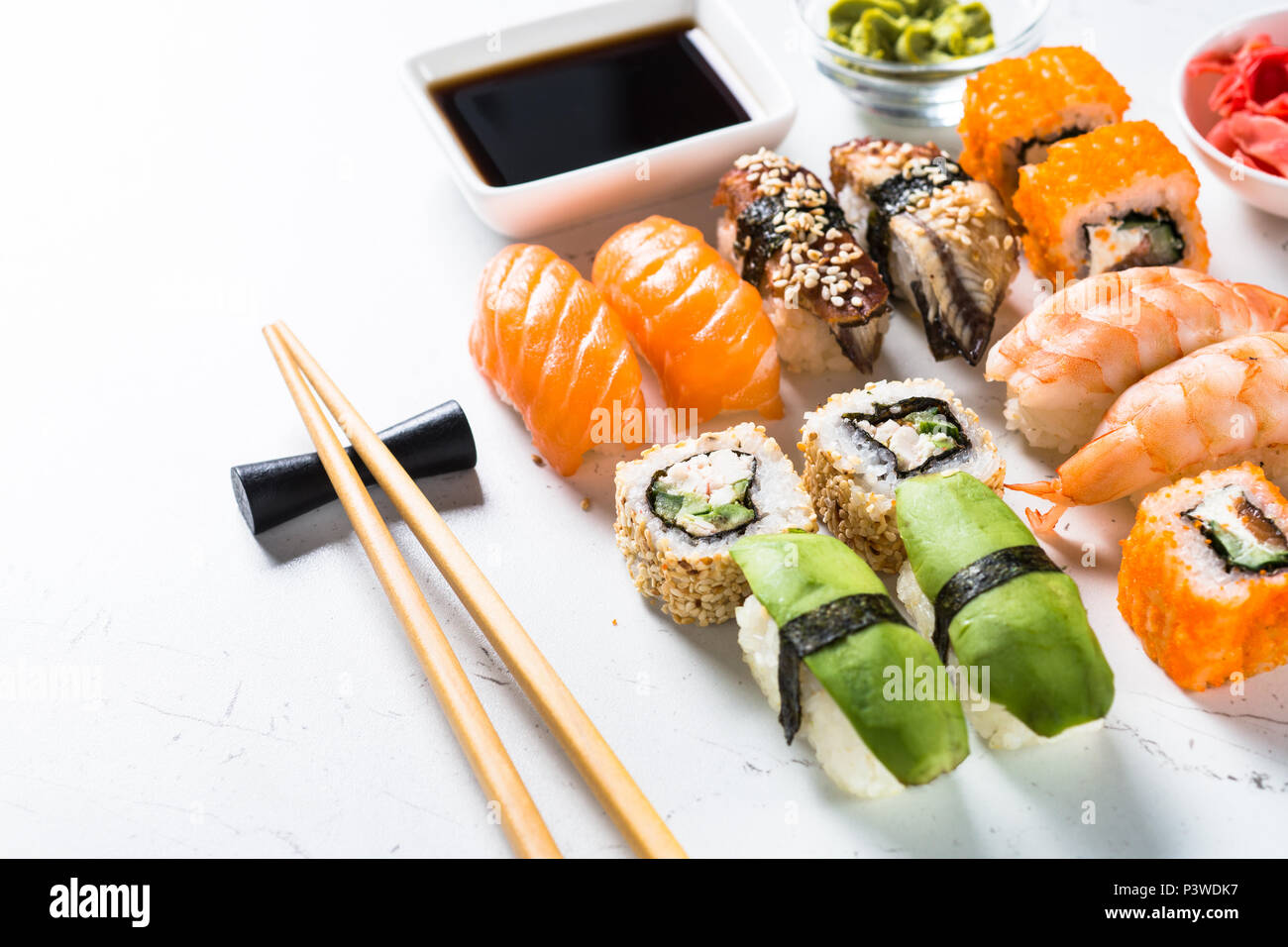 Sushi et sushi roll set sur fond blanc. Cuisine asiatique traditionnelle. Banque D'Images