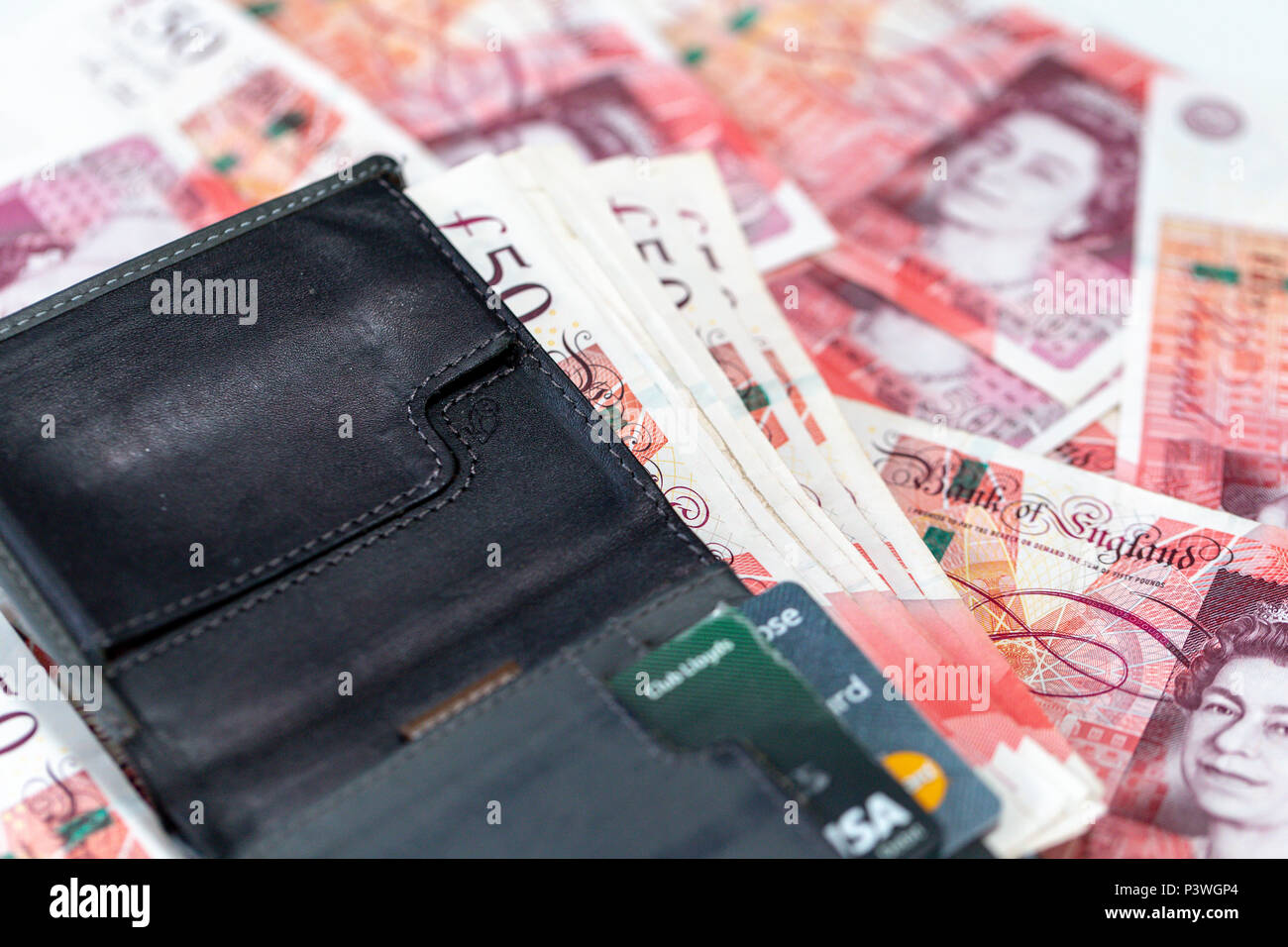 Un gros plan d'un portefeuille contenant des cartes de crédit et billets de banque 50 livres au-dessus de cinquante livres sterling notes éparses Banque D'Images