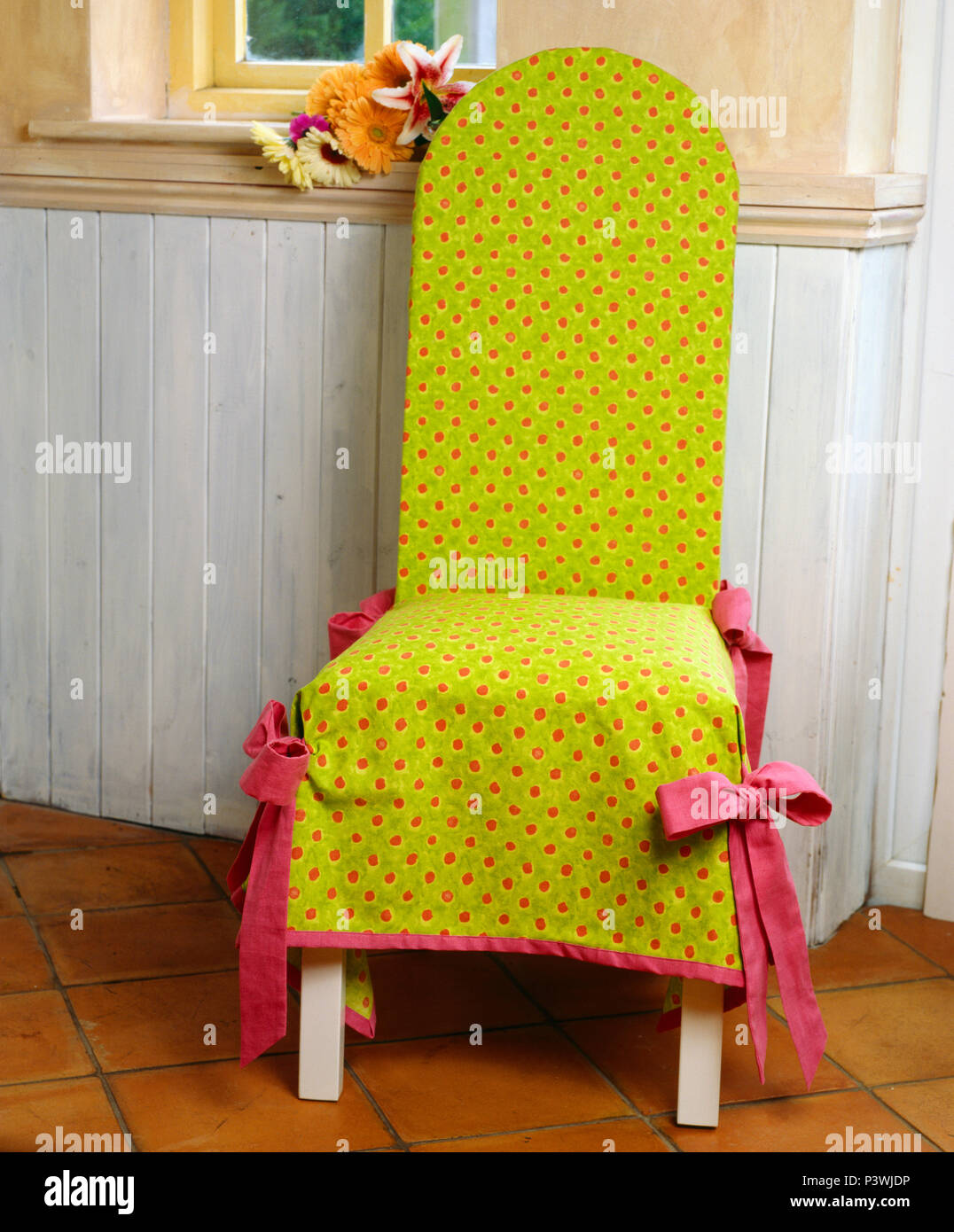 Close-up of pink-spotted lâche vert citron-couvercle sur chaise en bois peint contre dao Banque D'Images