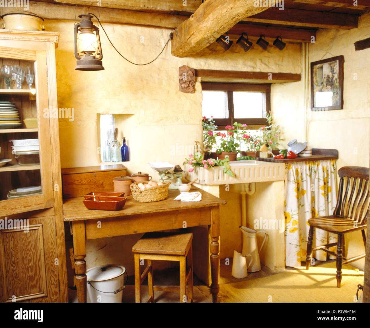 Évier en faïence dans cottsage avec petite cuisine vieille table en pin et  une chaise Windsor Photo Stock - Alamy