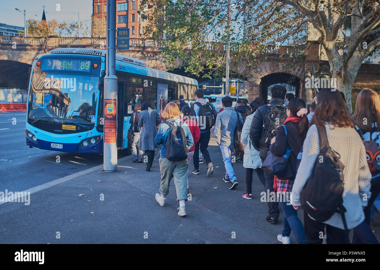 Une file d'attente d'étudiants de commencer à se faire sur un bus tôt le matin pour les emmener à l'université, Sydney, New South Wales, Australie, Banque D'Images