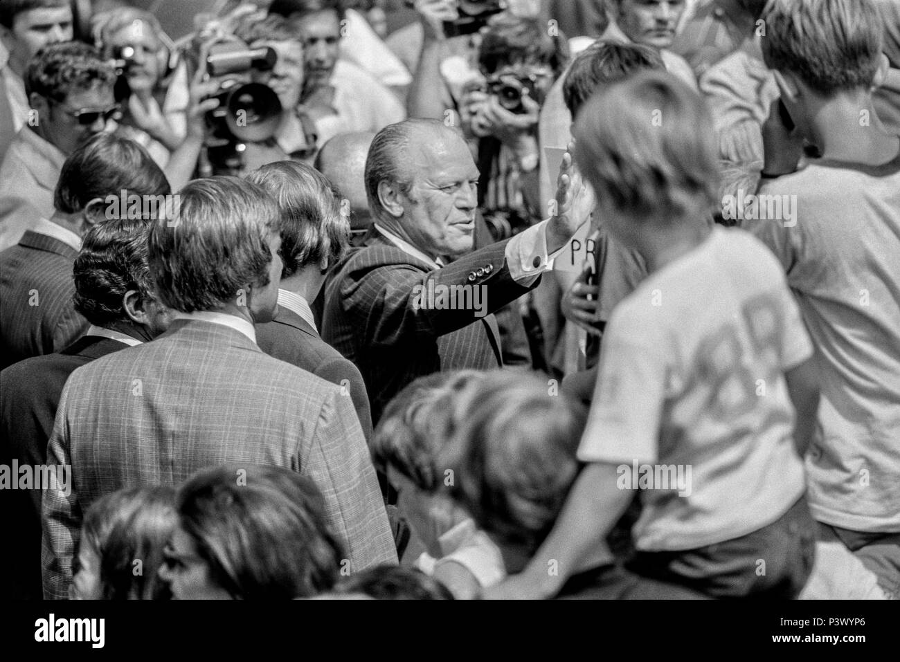 FORT SMITH, AR, USA - 10 août 1975 -- Le président Gerald Ford vagues pour les membres de la foule autour de lui après son discours d'ouverture du centre de réfugiés vietnamiens. Le centre, établi à Fort Chaffee, AR après la chute du gouvernement sud-vietnamien le logement a plus de 20 000 personnes quand le président s'est rendu. Banque D'Images