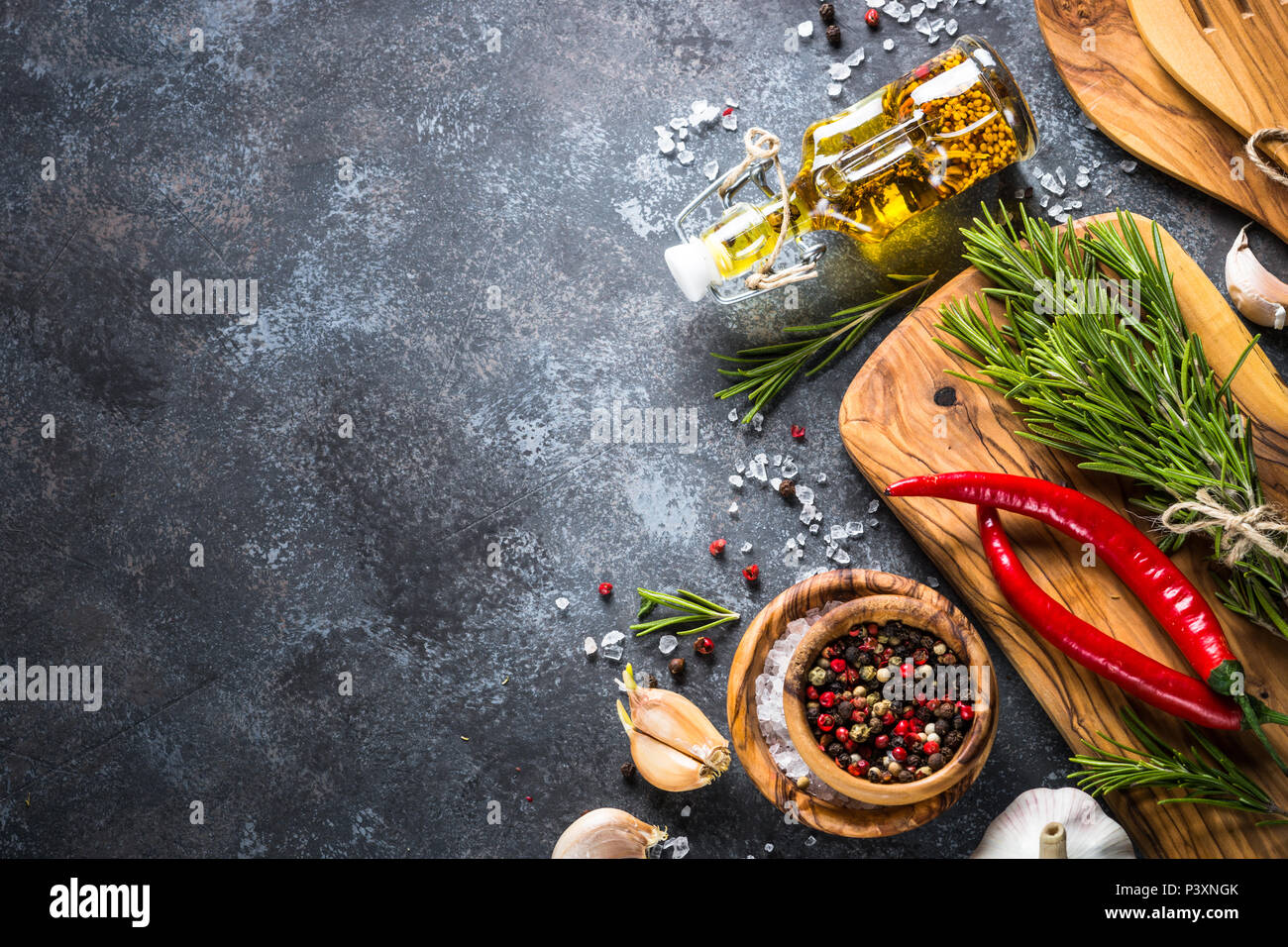 L'huile d'olive, les herbes et épices sur une table en pierre. Ingrédients pour la cuisine, vue de dessus, copiez l'espace. Banque D'Images