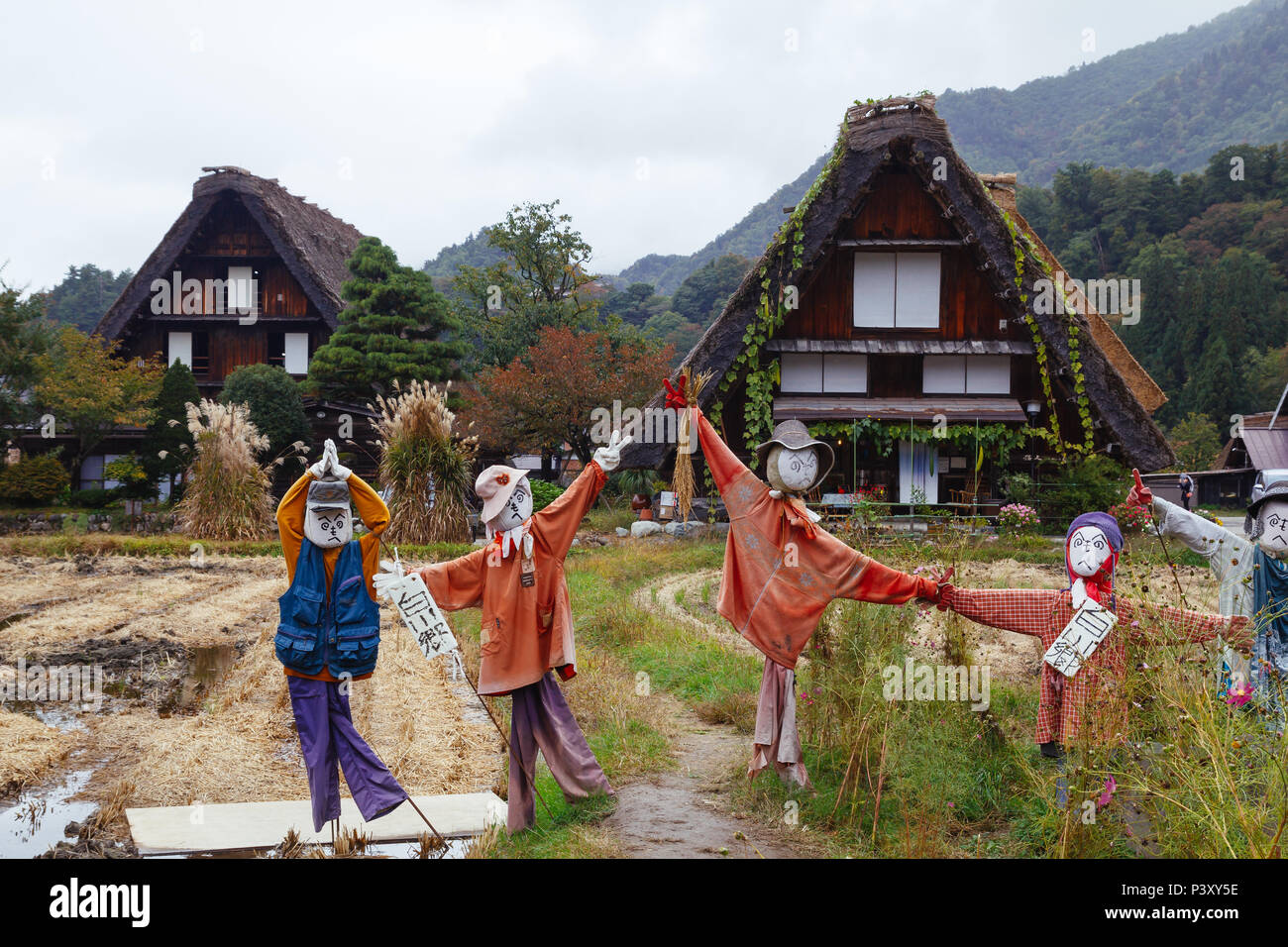 Des épouvantails en face de maisons traditionnelles en bois dans village Shirakawa-go, Japon Banque D'Images