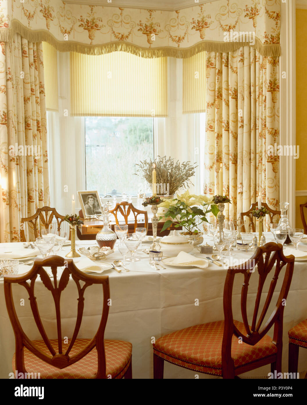 Aveugles et crème avec des rideaux frangé de caisse sur la fenêtre dans la salle à manger avec un chiffon de lin blanc sur la table pour le déjeuner Banque D'Images