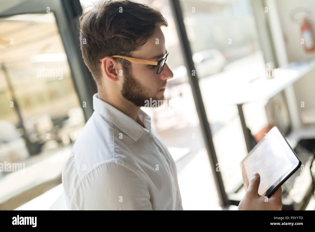 Businessman wearing glasses using tablet Banque D'Images