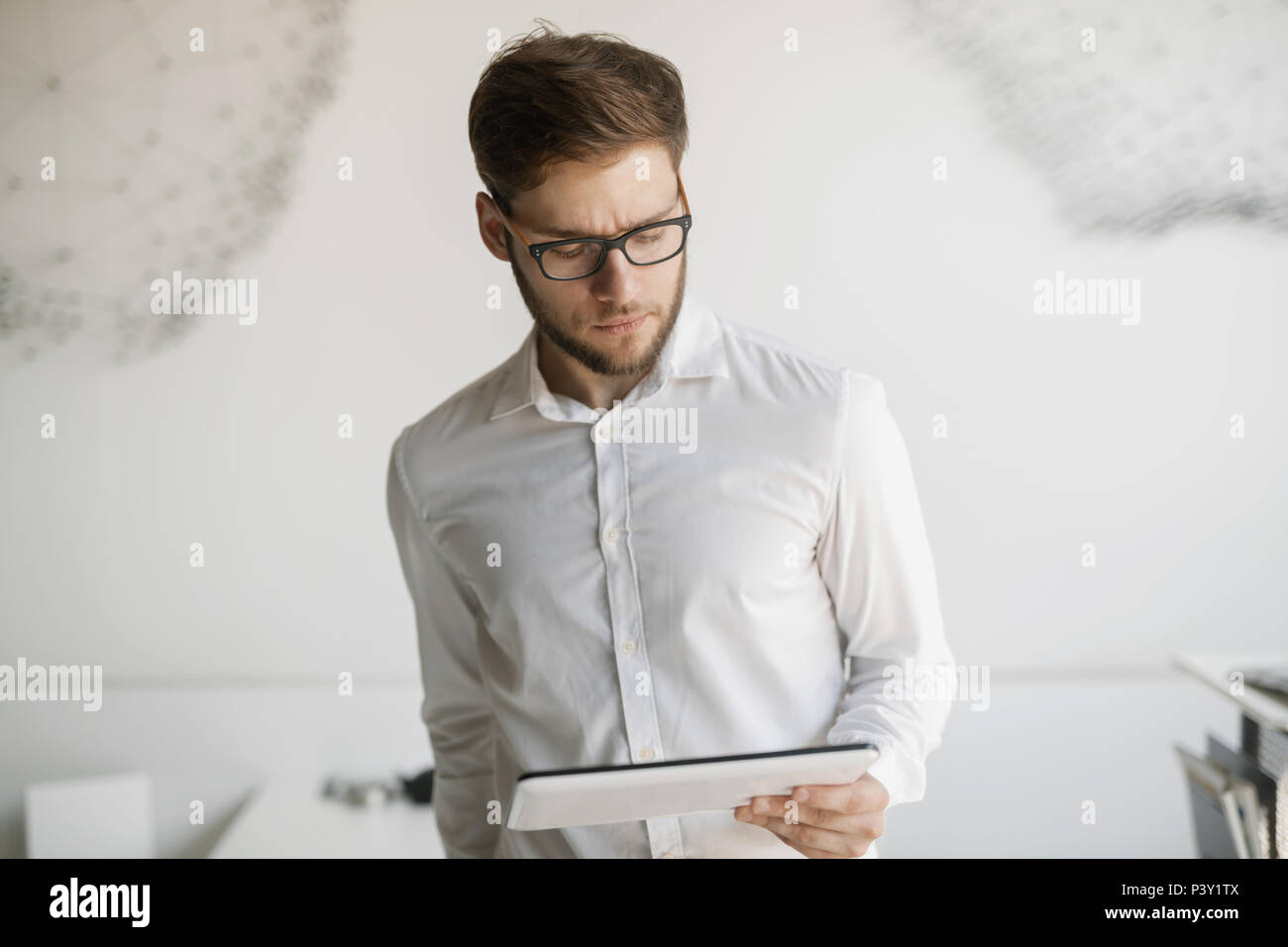 Businessman wearing glasses using tablet Banque D'Images