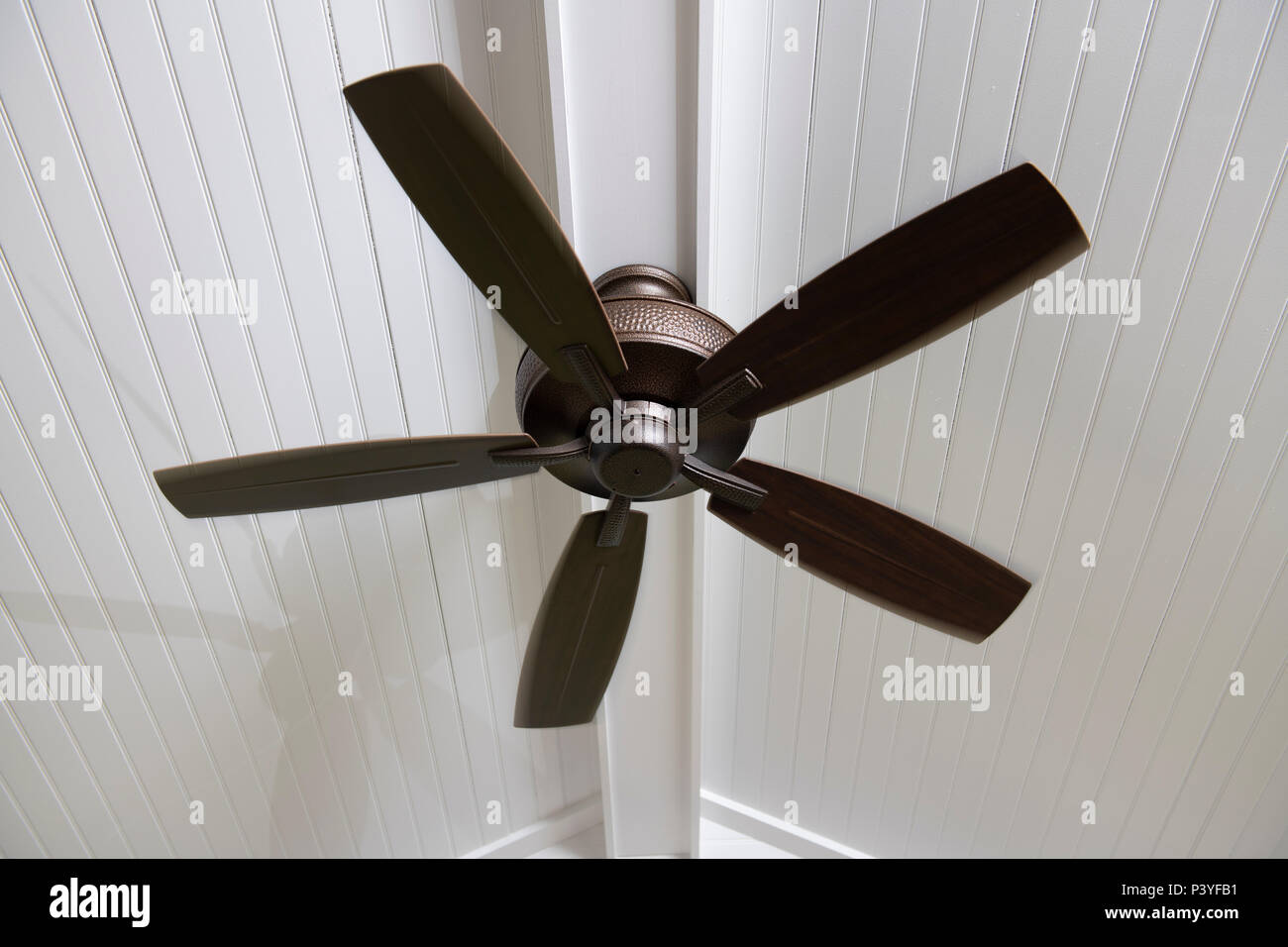 Un ventilateur au plafond électrique moderne sur une véranda pour aider à refroidir l'espace sur une chaude journée Banque D'Images