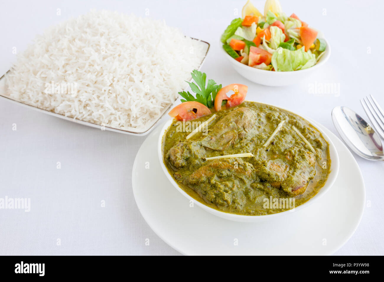 Les épinards poulet au curry avec du riz et une salade de légumes Banque D'Images