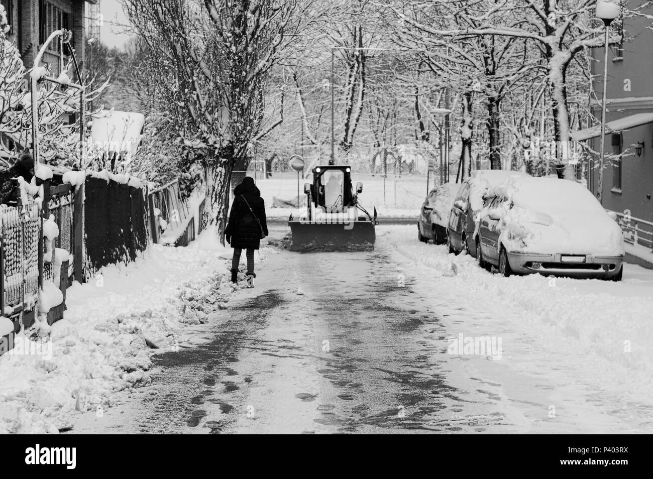 Une femme et un chasse-neige sur la rue d'un jour de neige (Pesaro, Italie) Banque D'Images