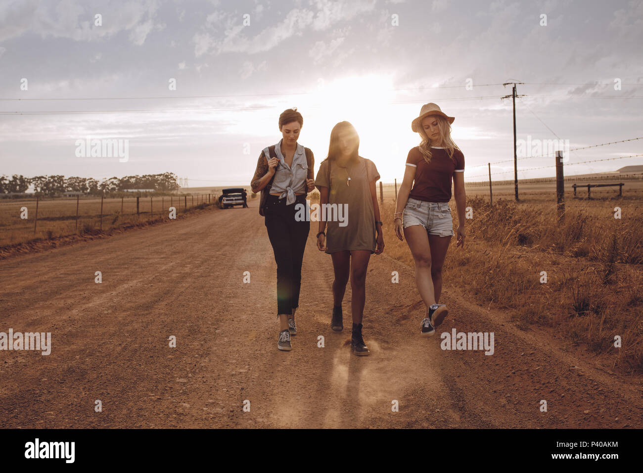 Toute la longueur de trois femmes déçus par quelques routes de campagne, laissant leurs ventilées voiture derrière. Les amis de quitter ventilées voiture derrière sur c Banque D'Images