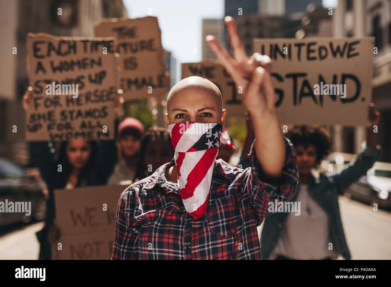 Militante avec bouche couverts gesturing signe de paix au cours de la démonstration sur rood. Groupe de femelles qui protestaient avec la paix et le silence. Banque D'Images