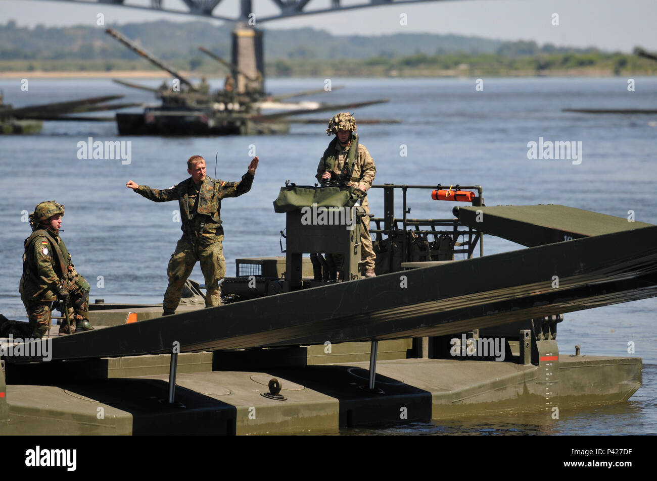 Dans le cadre d'une traversée de pont de démonstration, un Amphibioius Royaume-uni commandant dirige l'age les deux soldats allemand et britannique pour verrouiller le heavy metal d'un Ampbibious les rampes de forage pour l'autre afin de créer un pont sur une rivière importante à Chelmno, en Pologne le 8 juin pendant 16 ans. Anakonda Anakonda exercice 2016 est une multinationale dirigée par la Pologne, premier événement de formation tout au long de la Pologne juin 7-17. L'exercice implique plus de 25 000 participants de plus de 20 nations. Anakonda 16 est un événement de formation de l'armée américaine pour l'Europe et les nations participantes et démontre l'United Banque D'Images